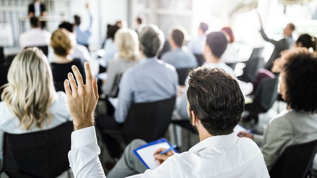 Person raising their hand during a lecture